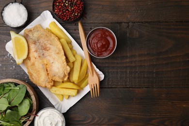 Delicious fish and chips served on wooden table, flat lay. Space for text