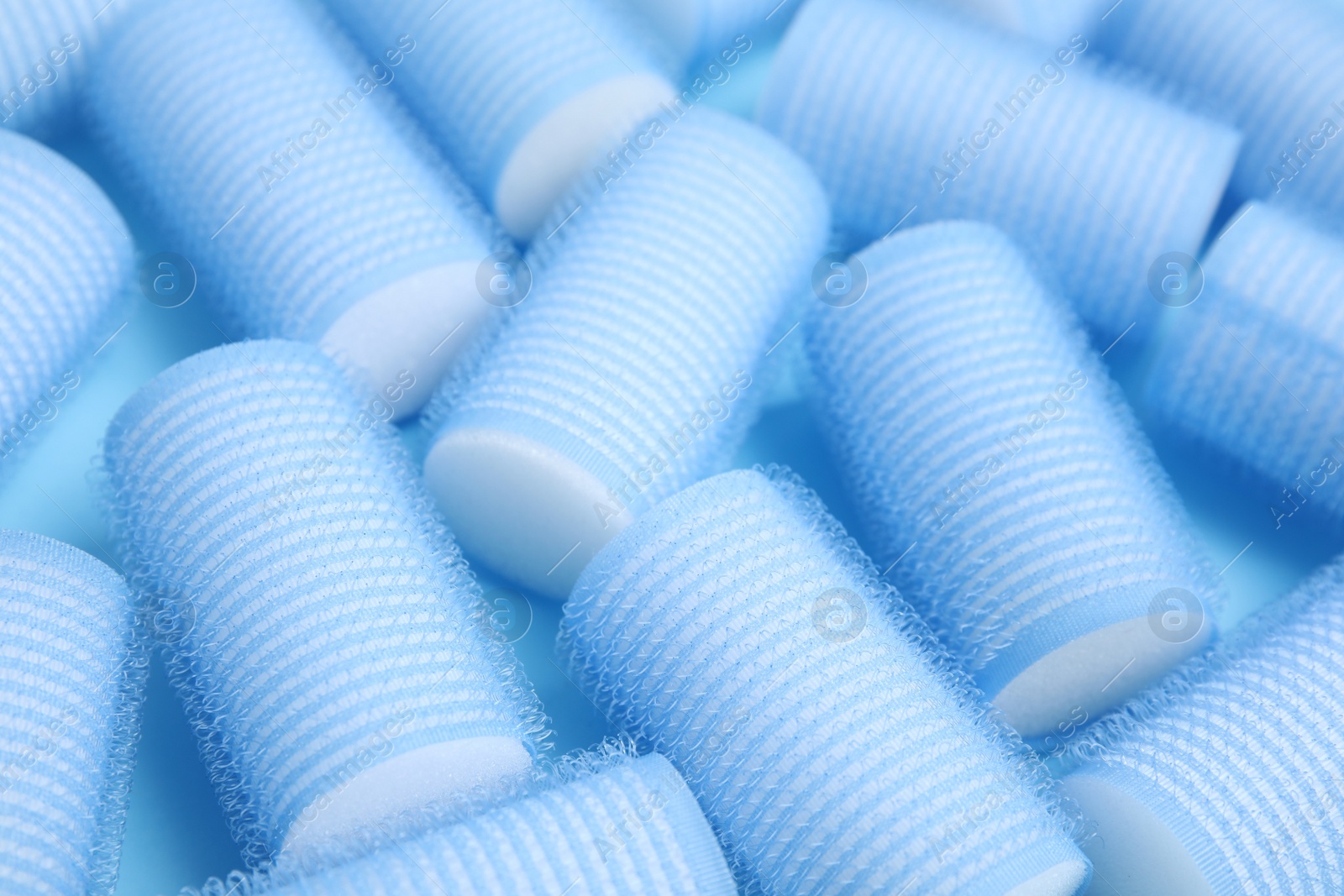 Photo of Hair curlers on turquoise background, closeup. Styling tool