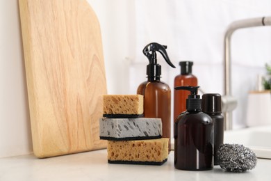 Different cleaning supplies on countertop in kitchen