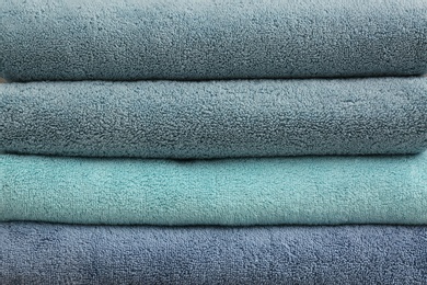 Photo of Stack of folded soft colorful towels as background