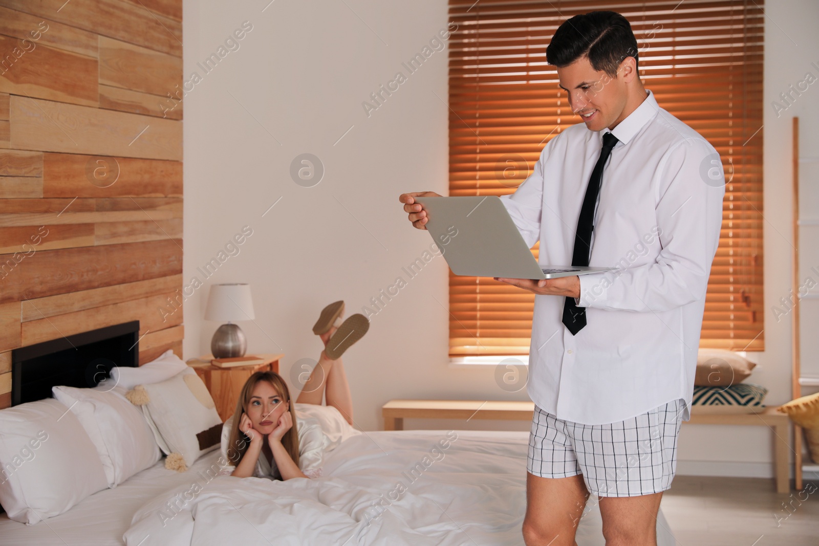 Photo of Man working on laptop in bedroom. Stay at home concept