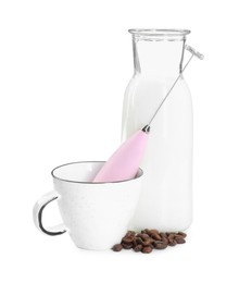 Pink mini mixer (milk frother), cup, coffee beans and bottle isolated on white