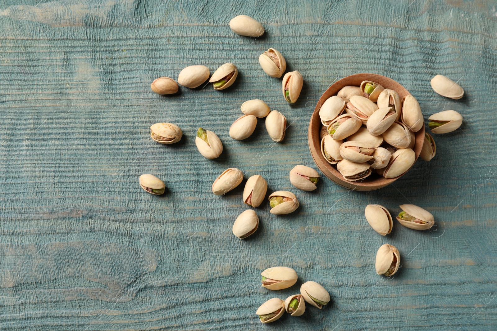 Photo of Composition with organic pistachio nuts on wooden table, flat lay. Space for text