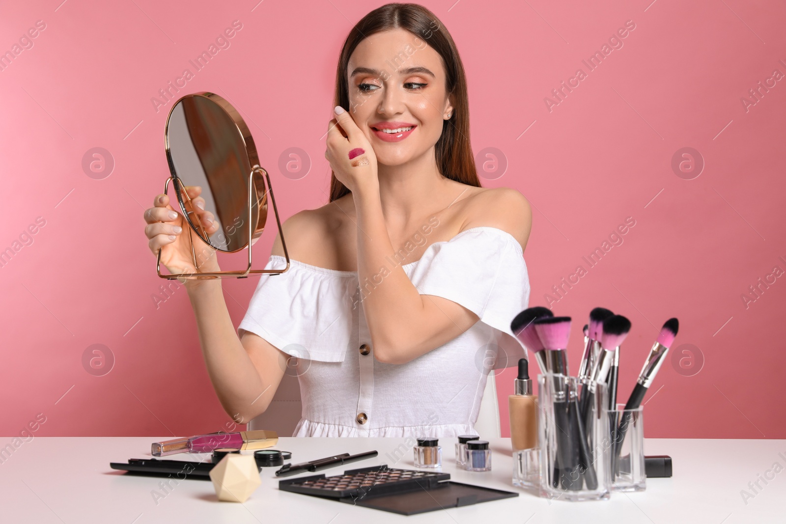 Photo of Beauty blogger with mirror on pink background