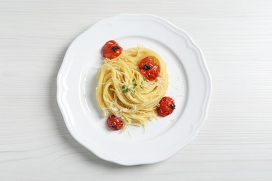 Tasty capellini with tomatoes and cheese on white wooden table, top view. Exquisite presentation of pasta dish