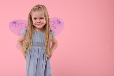 Cute little girl in fairy costume with violet wings on pink background, space for text