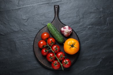 Photo of Fresh ripe vegetables on black table, top view
