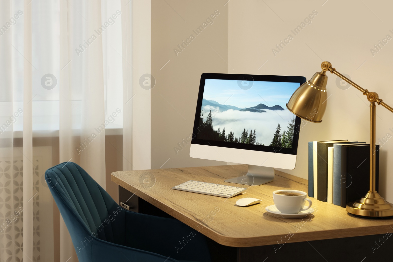 Photo of Cozy workspace with computer on wooden desk and comfortable chair at home