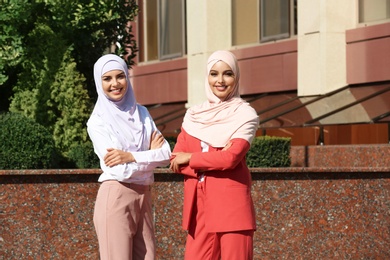 Muslim women in hijabs outdoors on sunny day