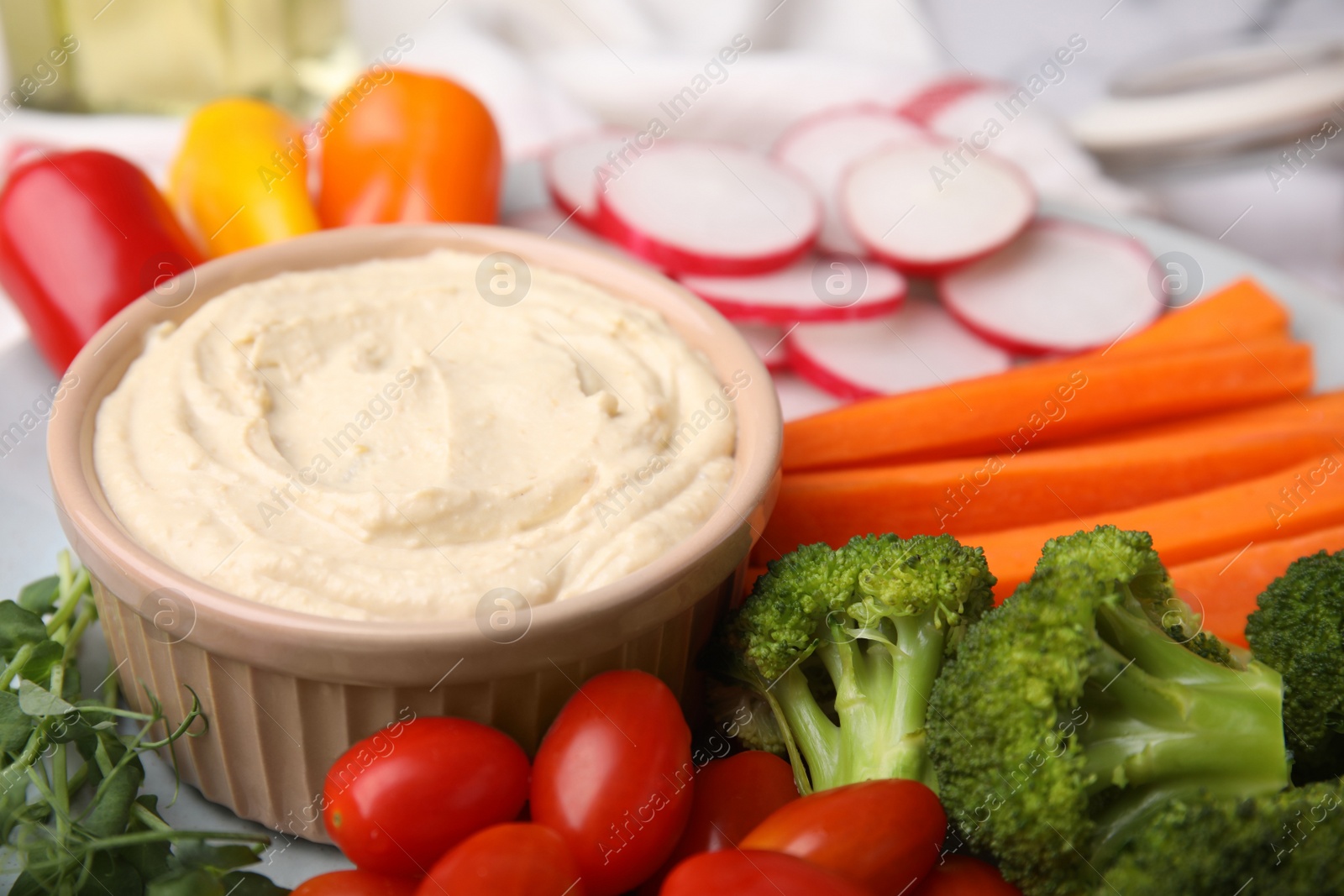 Photo of Plate with delicious hummus and fresh vegetables, closeup