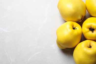 Photo of Fresh ripe organic quinces on light table, flat lay. Space for text