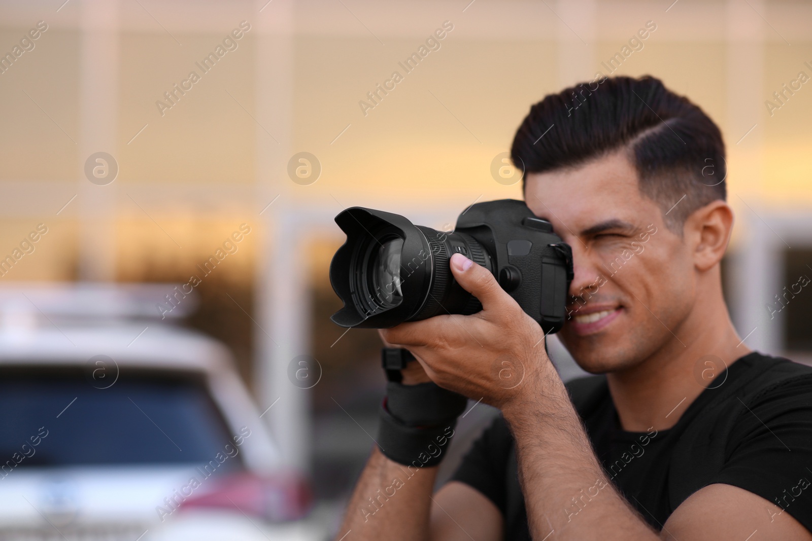 Photo of Photographer taking picture with professional camera outdoors at sunset