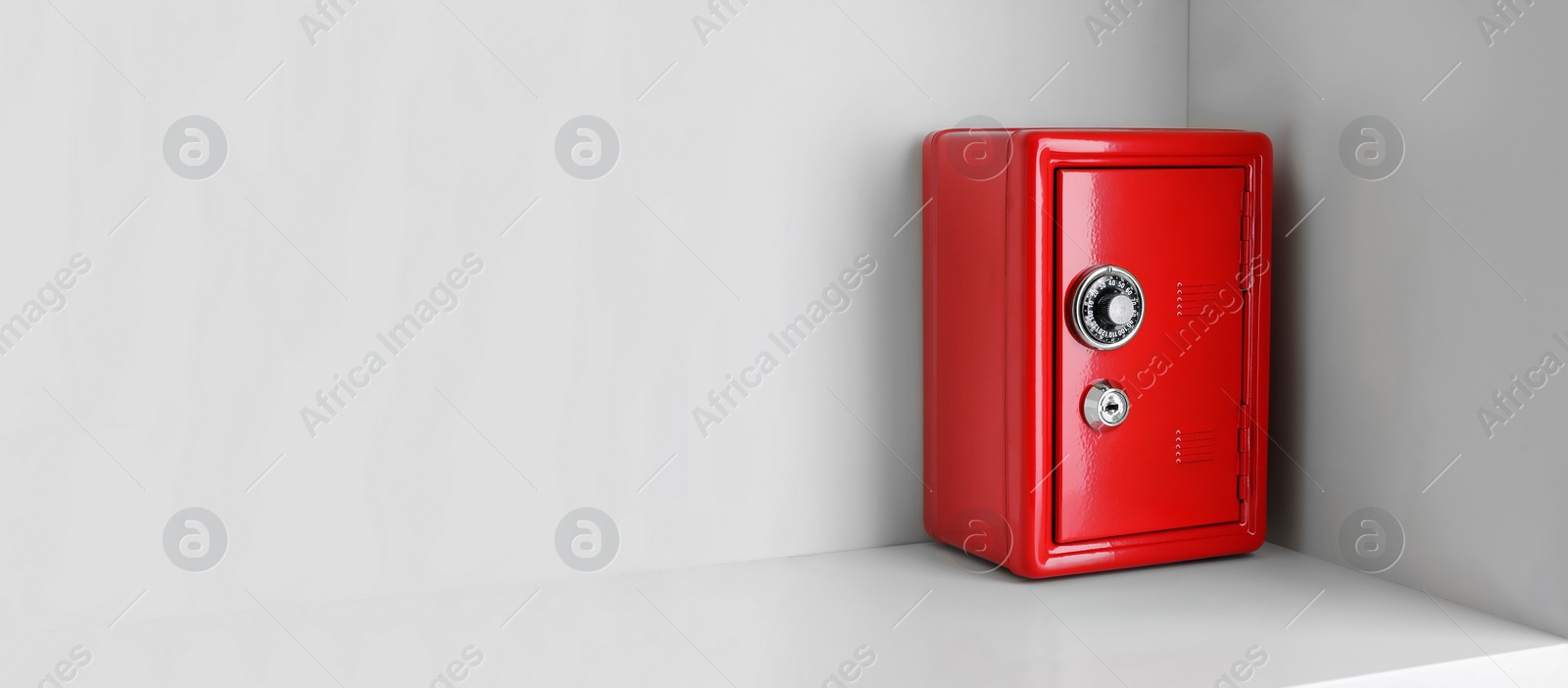 Image of Red steel safe with mechanical combination lock on shelf, space for text. Banner design