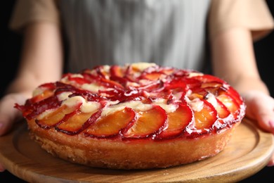 Woman with delicious plum cake, closeup view