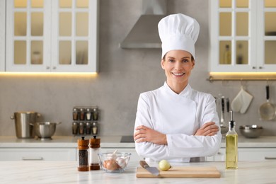 Photo of Portrait of professional chef near table with ingredients at kitchen. Space for text