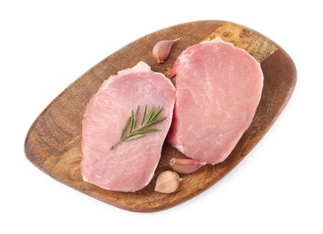 Wooden board with pieces of raw pork meat, rosemary and garlic isolated on white, top view