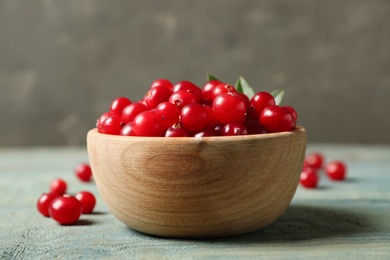 Photo of Tasty ripe cranberries on light blue wooden table, closeup