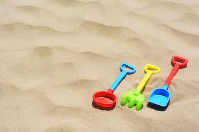 Photo of Set of colorful beach toys on sand. Space for text