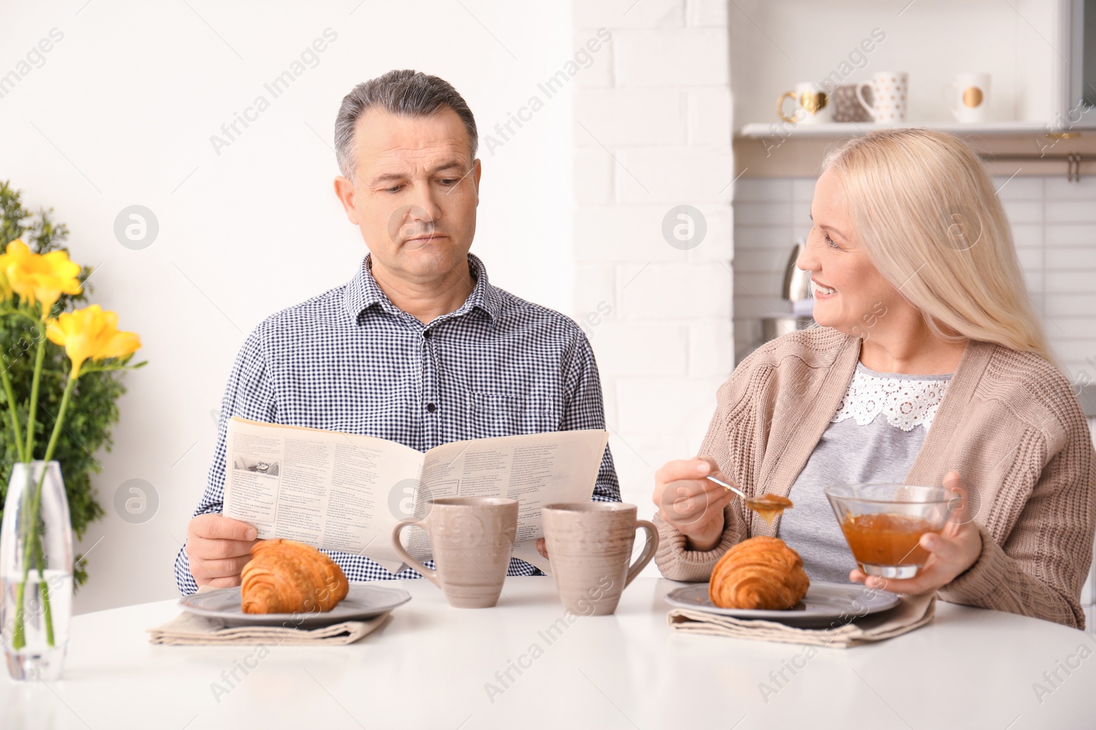 Photo of Happy senior couple having breakfast together at home