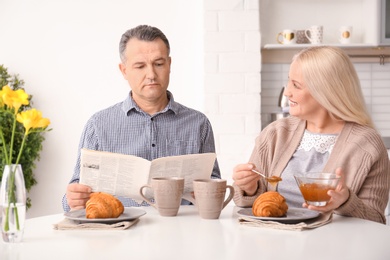 Happy senior couple having breakfast together at home