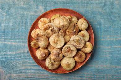 Tasty dried figs on light blue wooden table, top view