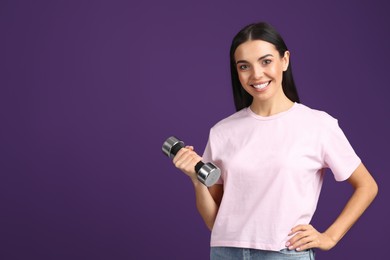 Woman with dumbbell as symbol of girl power on purple background, space for text. 8 March concept