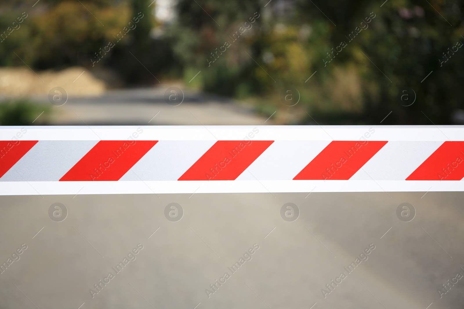 Photo of Closed boom barrier in city on sunny day, closeup