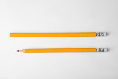 Photo of Pencil with point and unsharpened one on white background, top view