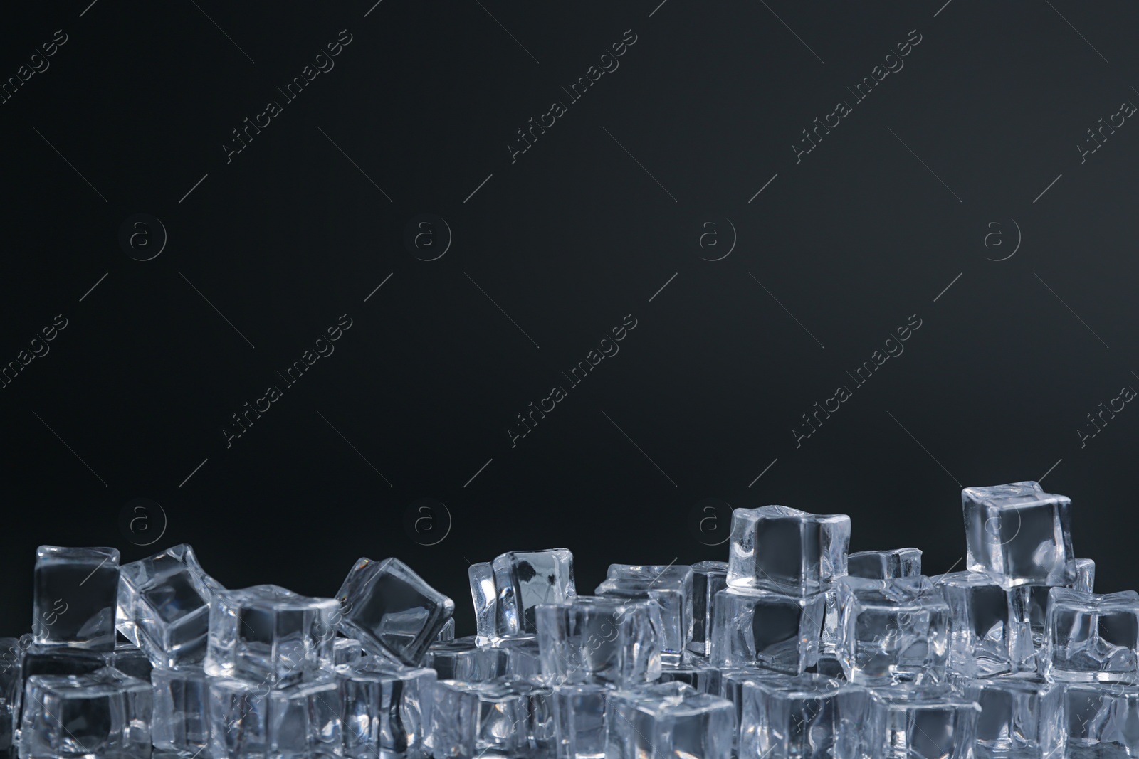 Photo of Crystal clear ice cubes on black background. Space for text