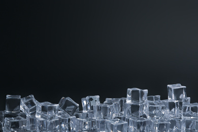 Photo of Crystal clear ice cubes on black background. Space for text