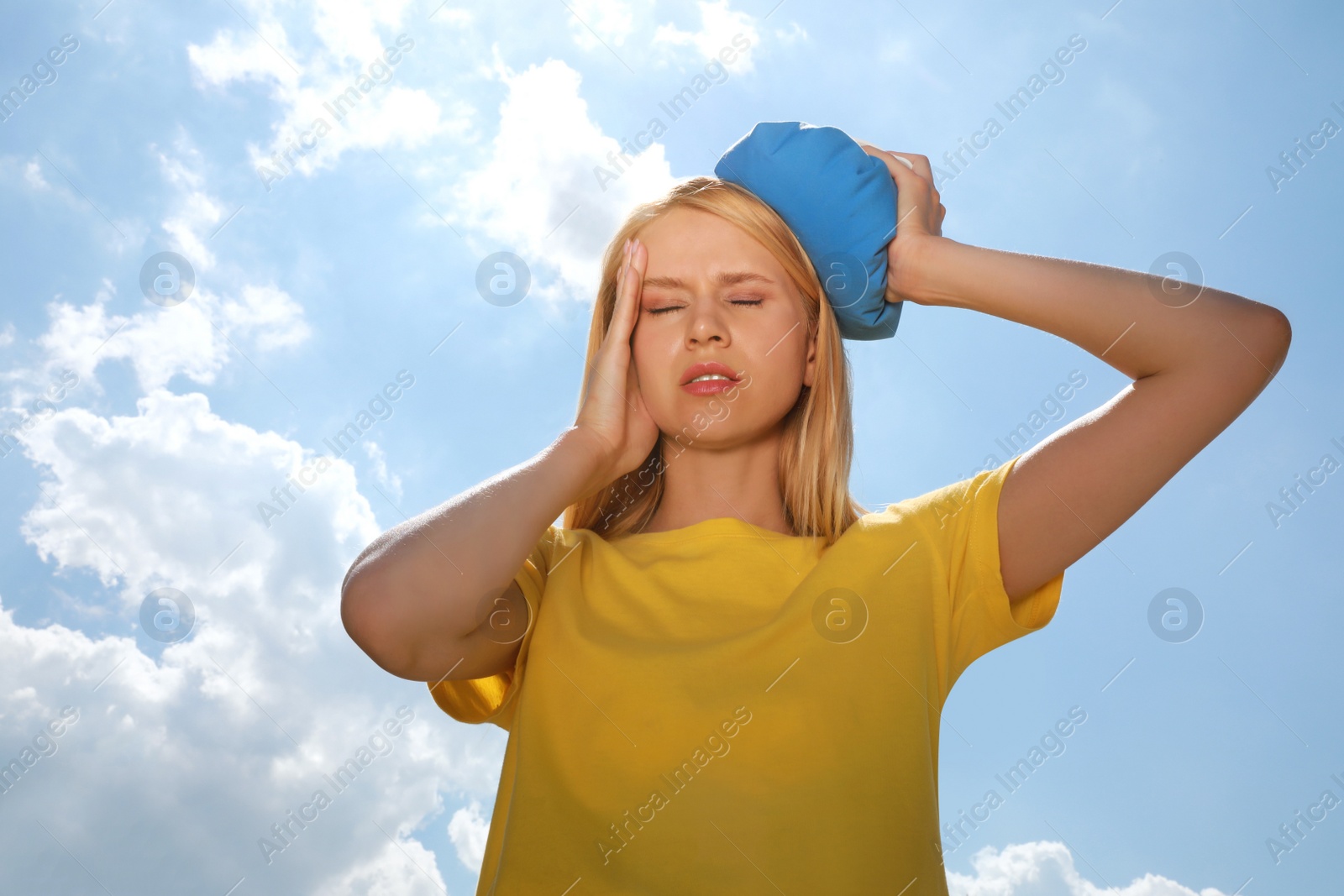 Photo of Woman with cold pack suffering from heat stroke outdoors