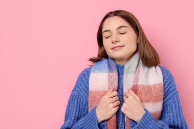 Photo of Beautiful woman in warm scarf on pink background, space for text