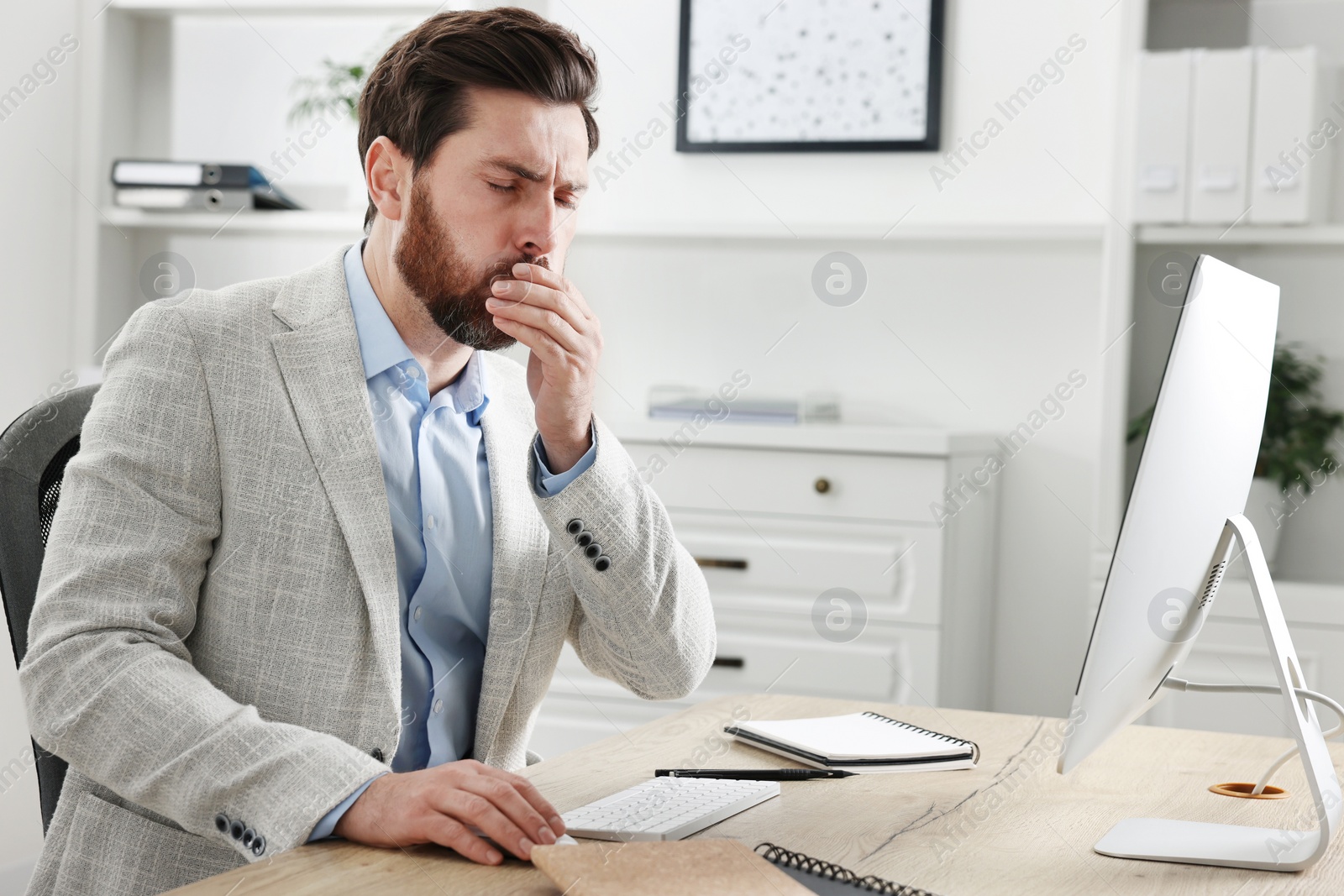 Photo of Sick man coughing at workplace in office. Cold symptoms