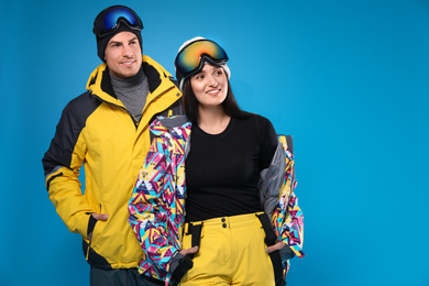 Photo of Couple wearing stylish winter sport clothes on light blue background