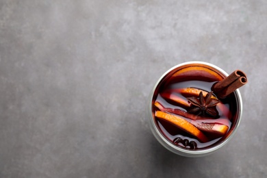 Aromatic mulled wine on grey table, top view. Space for text