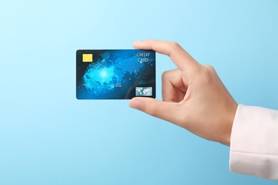 Photo of Woman holding credit card on color background