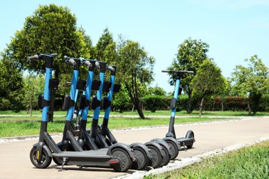 Many modern electric scooters in park. Rental service