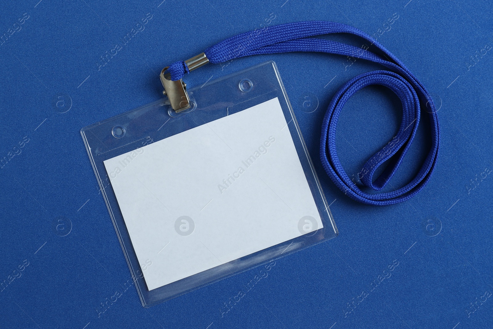 Photo of Blank badge on blue background, top view. Mockup for design