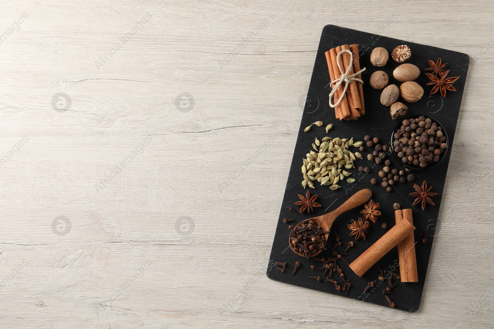 Photo of Different spices on wooden table, top view. Space for text