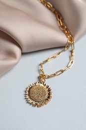 Photo of Elegant necklace and beige cloth on white table