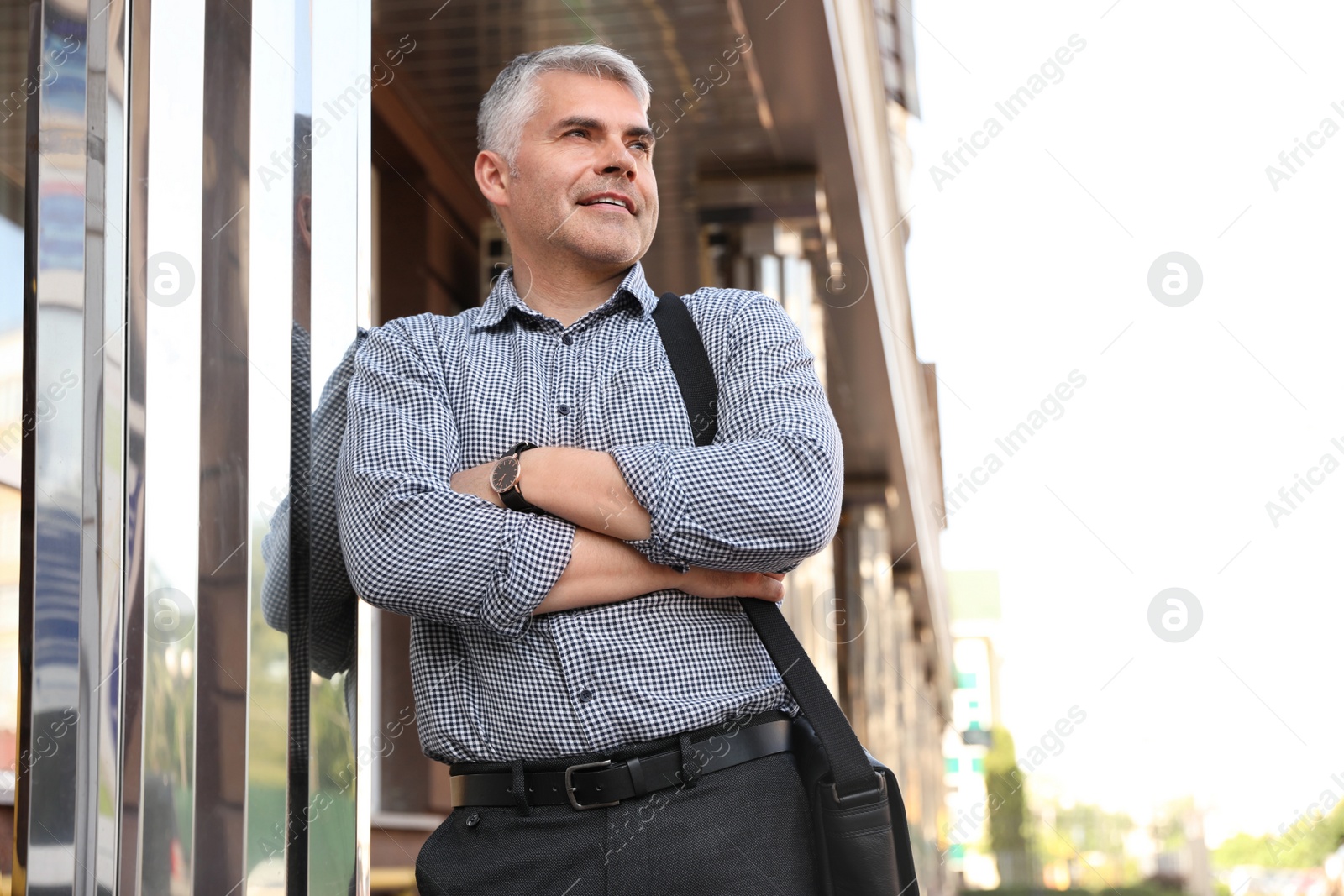 Photo of Portrait of handsome businessman in city, space for text