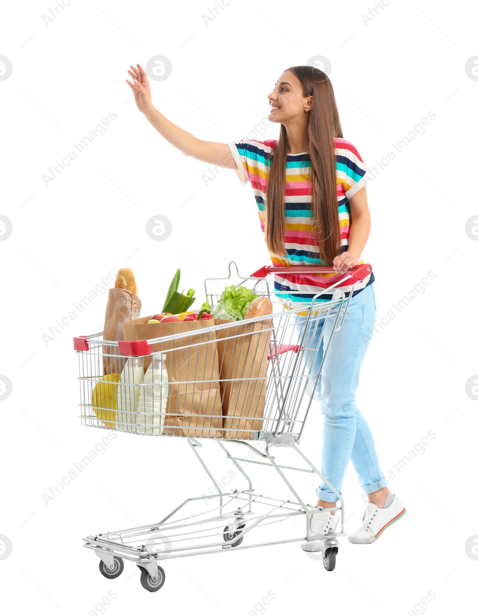 Photo of Young woman with full shopping cart on white background