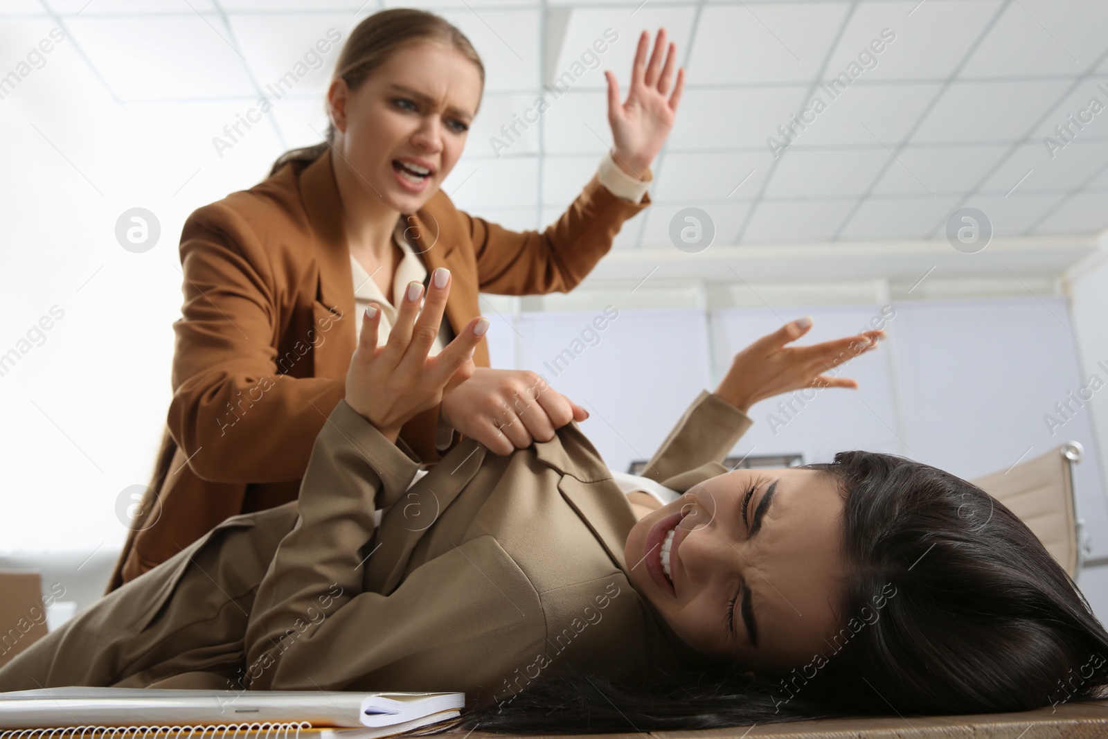 Photo of Emotional colleagues fighting in office. Workplace conflict