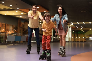 Happy family spending time at roller skating rink