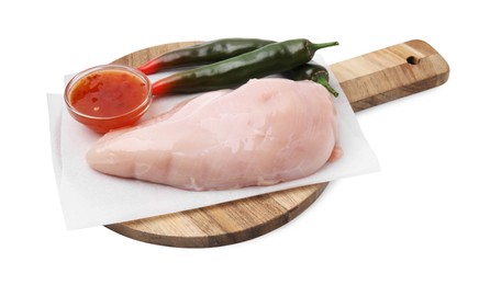 Photo of Marinade, basting brush, raw chicken fillets and chili peppers isolated on white