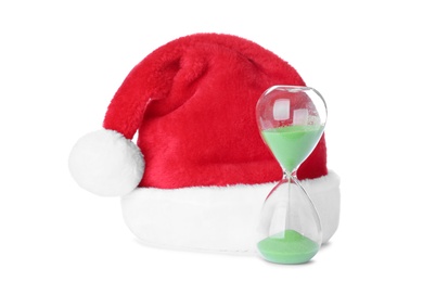 Photo of Hourglass and Santa hat on white background. Christmas countdown