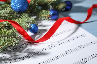 Composition with Christmas decor and music sheets on table, closeup