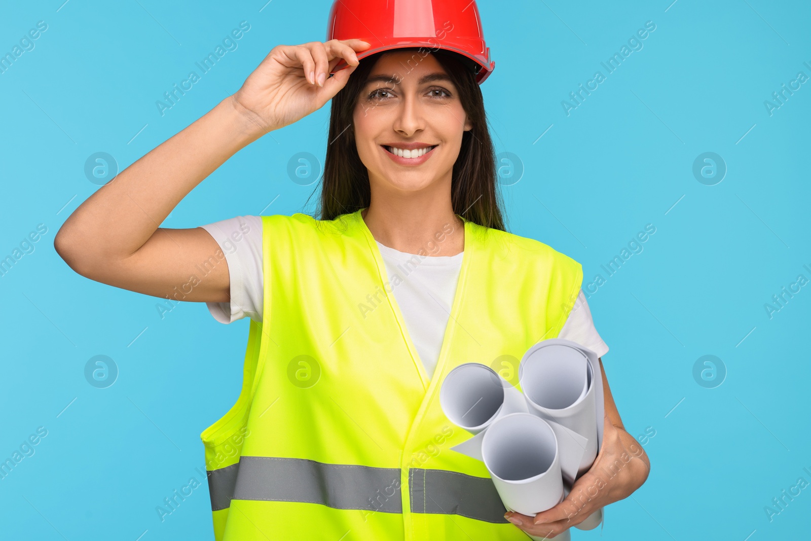 Photo of Architect in hard hat with drafts on light blue background