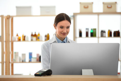 Photo of Professional pharmacist working with computer in drugstore