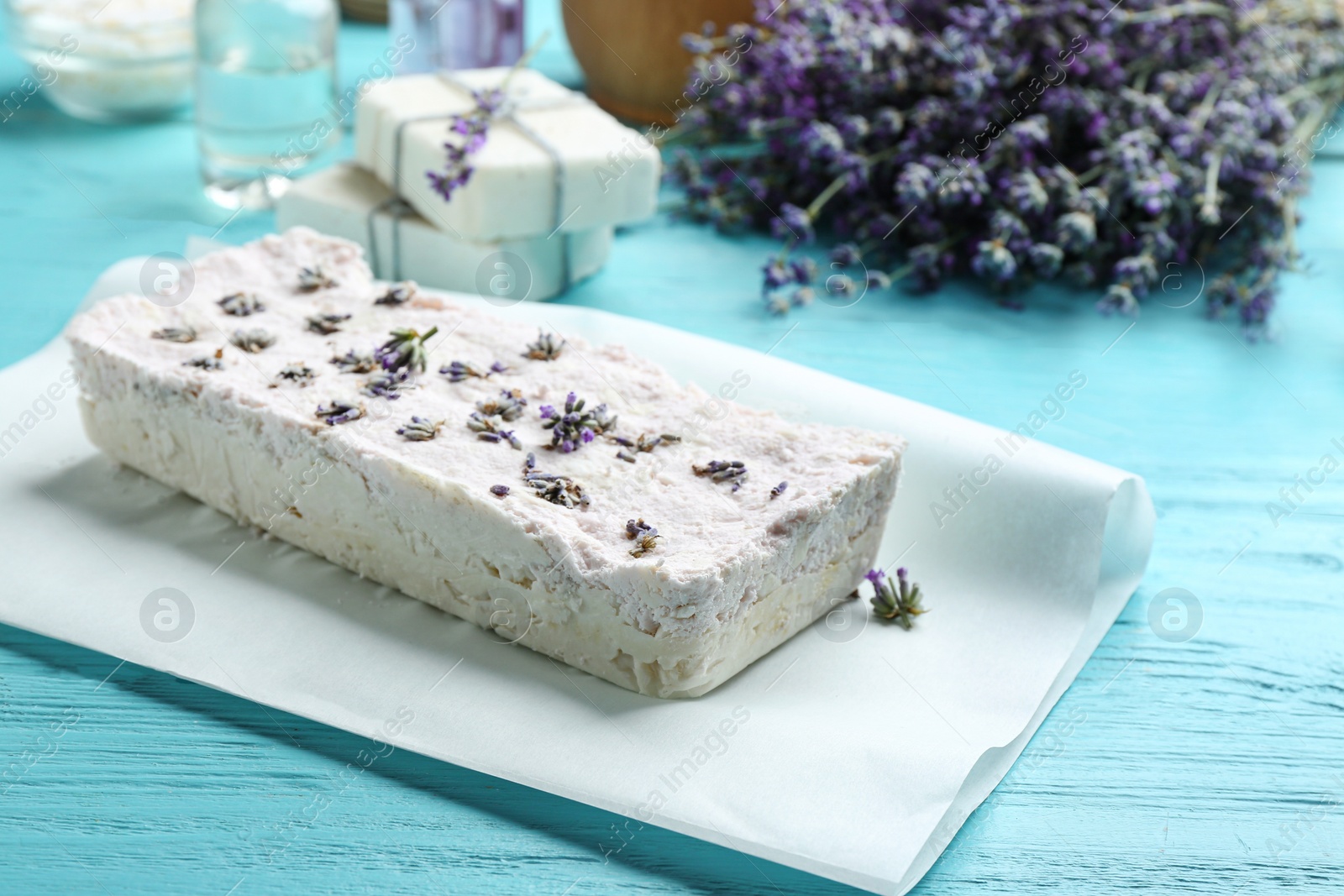 Photo of Hand made soap bar with lavender flowers on light blue wooden table